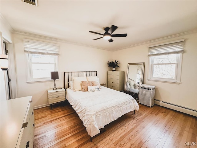 bedroom featuring hardwood / wood-style floors, a ceiling fan, visible vents, and ornamental molding