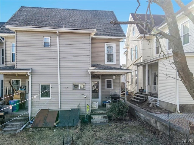 rear view of house featuring a shingled roof