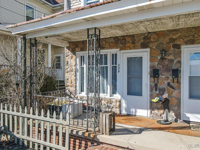 entrance to property featuring stone siding and covered porch