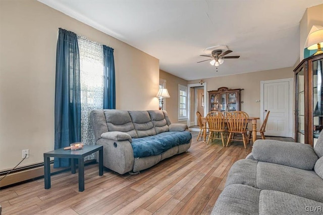 living room featuring a baseboard heating unit, light wood-type flooring, and a ceiling fan