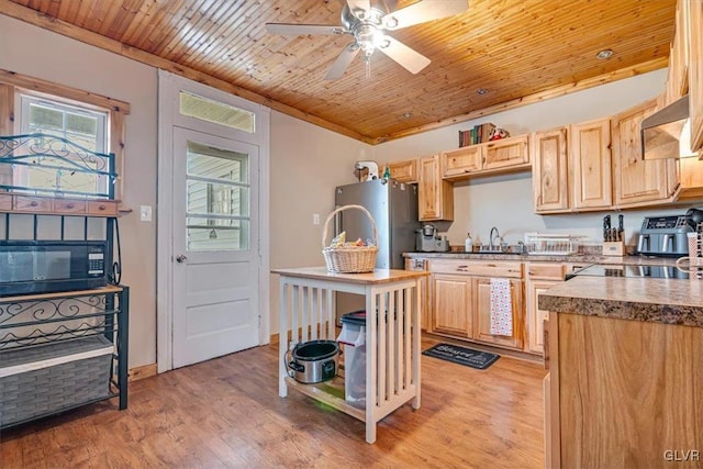 kitchen with light wood finished floors, freestanding refrigerator, a sink, light brown cabinetry, and wood ceiling