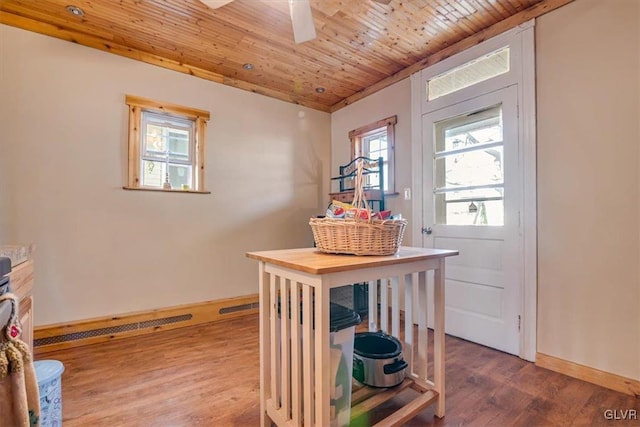 interior space with a ceiling fan, wood finished floors, wood ceiling, and baseboards