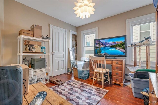 office with a chandelier, a baseboard radiator, and hardwood / wood-style flooring