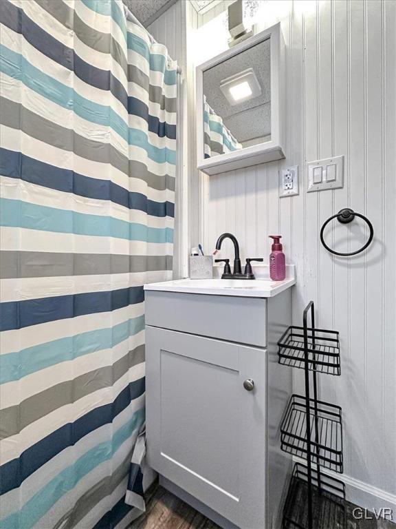 bathroom with a shower with curtain, wood finished floors, and vanity