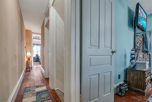 hallway with baseboards and dark wood-style flooring