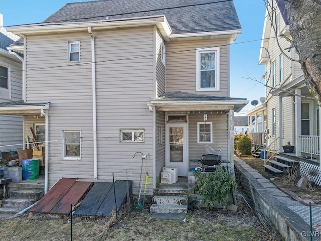 rear view of house featuring a shingled roof