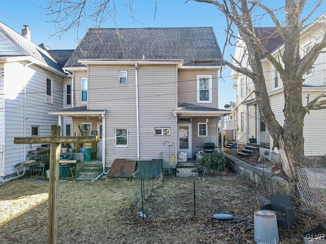 rear view of house featuring a shingled roof