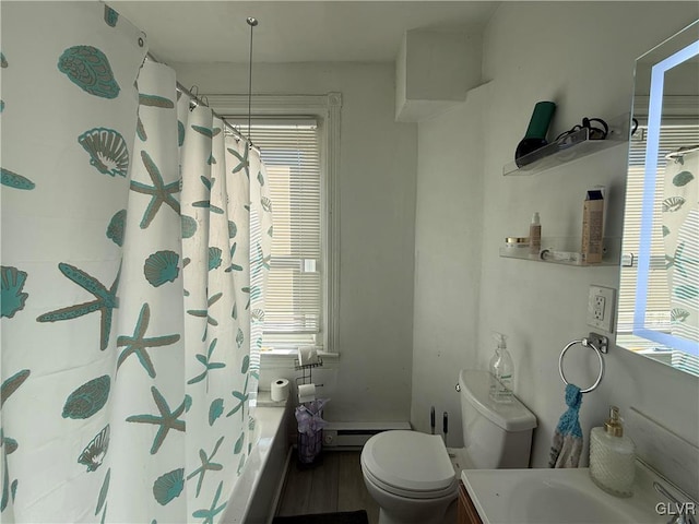 bathroom featuring toilet, a healthy amount of sunlight, and baseboard heating