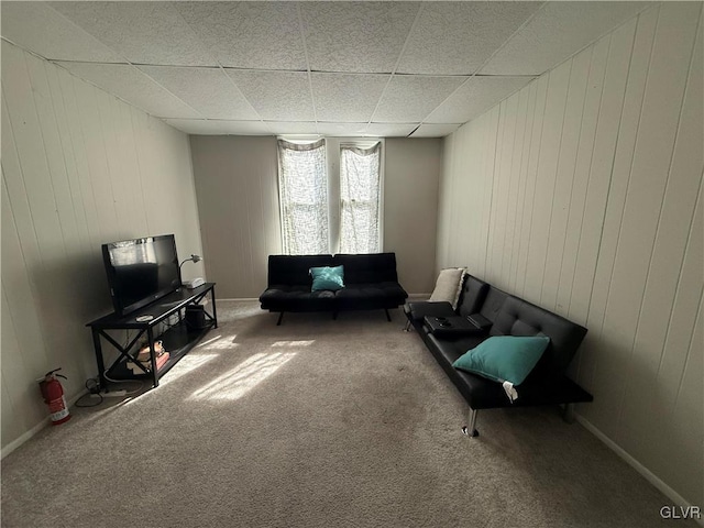 unfurnished room featuring carpet, baseboards, and a drop ceiling