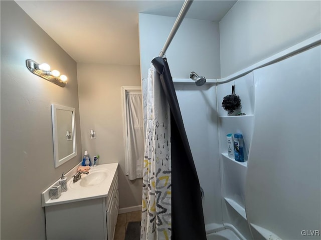 bathroom featuring vanity, curtained shower, and baseboards