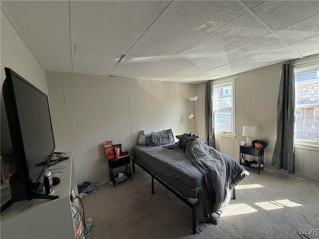 carpeted bedroom with multiple windows and a paneled ceiling