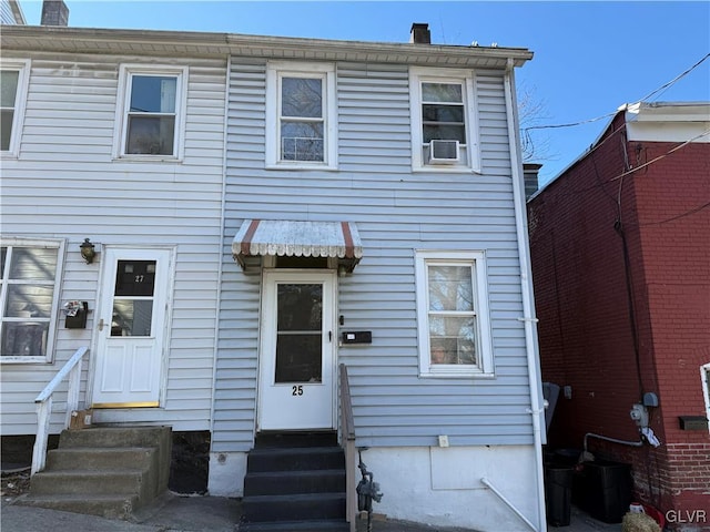 back of property with cooling unit, a chimney, and entry steps