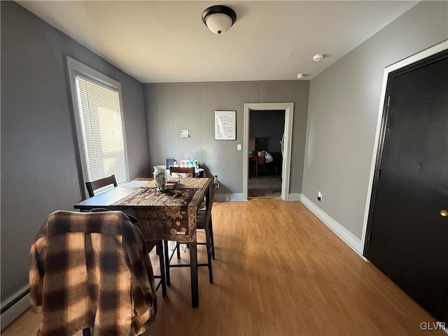 dining room with light wood-style flooring, baseboards, and baseboard heating