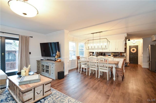 dining room with a wealth of natural light, wood finished floors, a chandelier, and crown molding