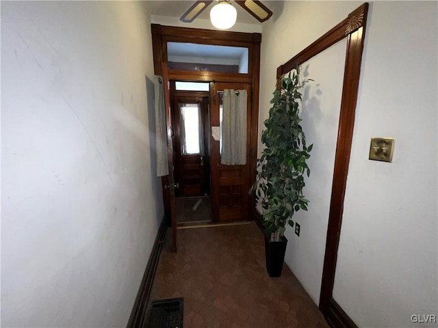 entryway featuring visible vents, dark carpet, and ceiling fan