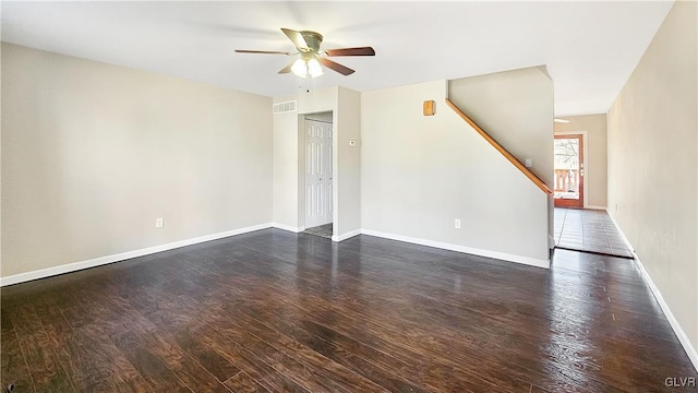 unfurnished living room featuring visible vents, ceiling fan, baseboards, stairs, and dark wood-style floors