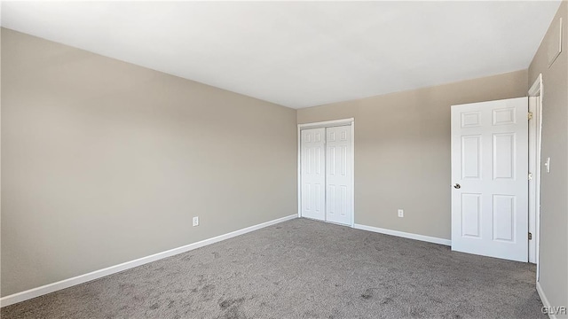 unfurnished bedroom featuring carpet flooring, baseboards, and a closet