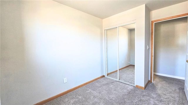 unfurnished bedroom featuring a closet, baseboards, and carpet flooring