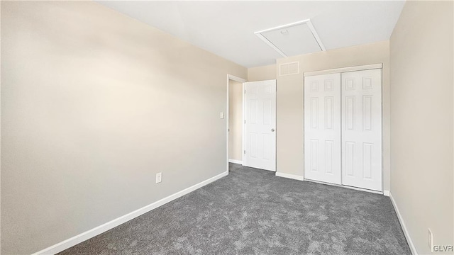 unfurnished bedroom with a closet, visible vents, baseboards, and dark colored carpet