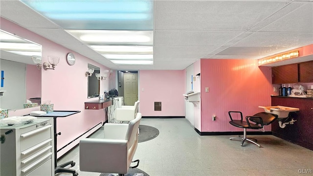 office featuring tile patterned floors, a drop ceiling, baseboard heating, and baseboards