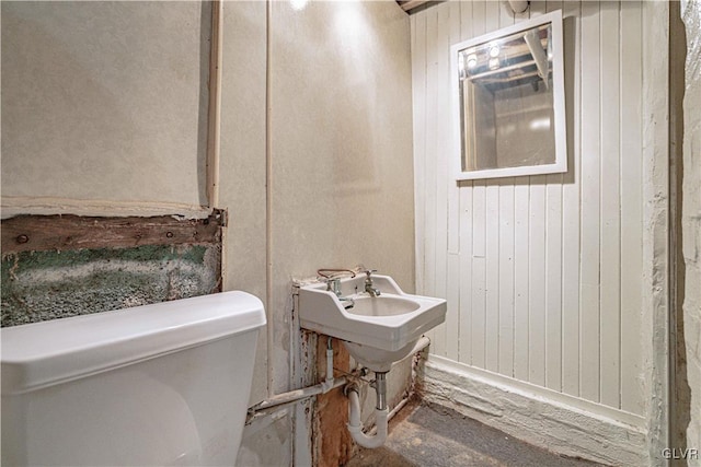 half bathroom with wood walls and toilet