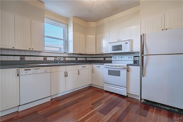 kitchen featuring white appliances, dark wood-style flooring, a sink, dark countertops, and backsplash