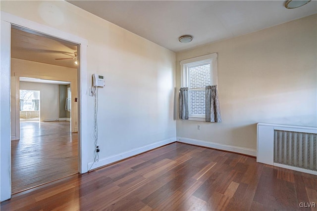 unfurnished room with ceiling fan, wood finished floors, visible vents, and baseboards