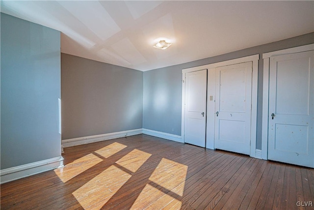 unfurnished bedroom featuring hardwood / wood-style floors and baseboards