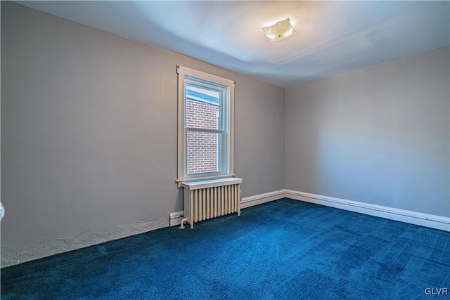 empty room featuring baseboards, dark carpet, and radiator heating unit