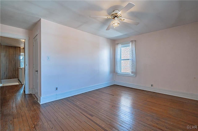 spare room featuring a ceiling fan, baseboards, and hardwood / wood-style flooring