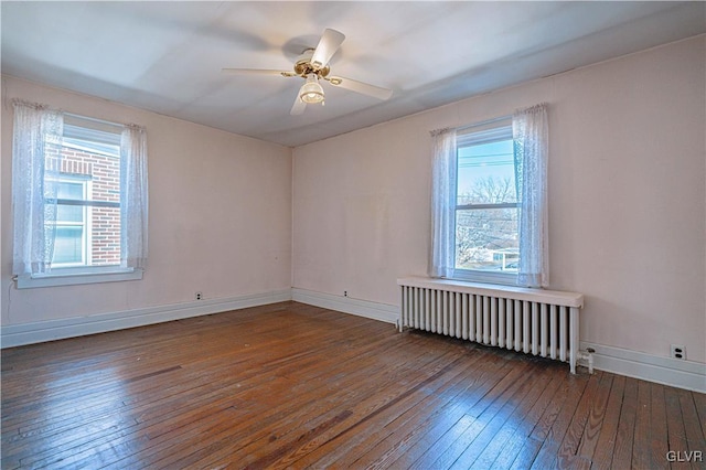 unfurnished room featuring ceiling fan, radiator heating unit, baseboards, and wood-type flooring