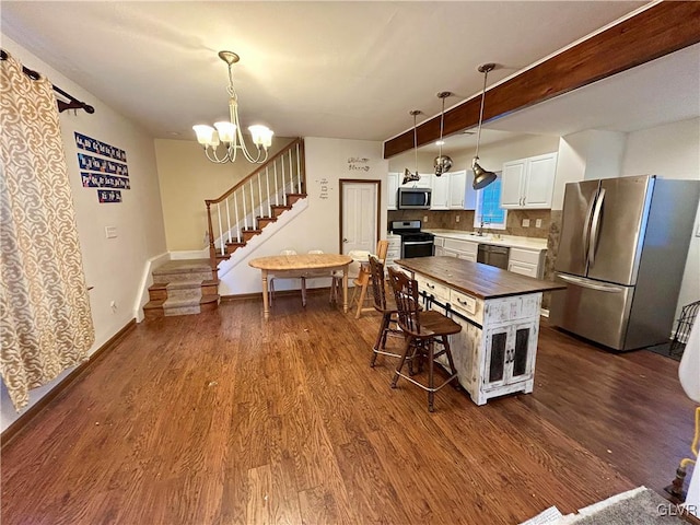 kitchen with dark wood finished floors, wood counters, white cabinetry, and stainless steel appliances