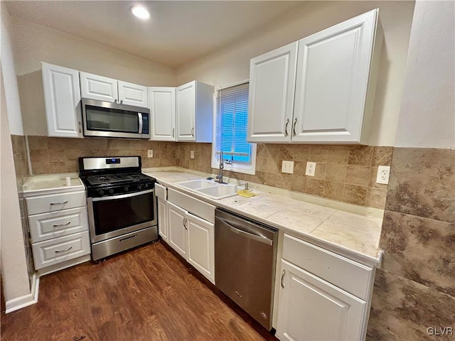 kitchen with dark wood-style floors, white cabinetry, stainless steel appliances, and a sink