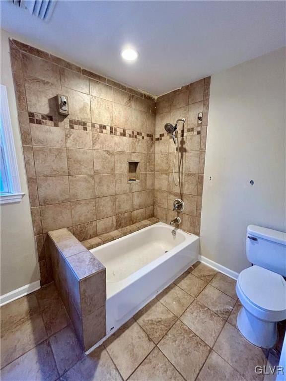 bathroom featuring toilet, baseboards, and shower / bathtub combination