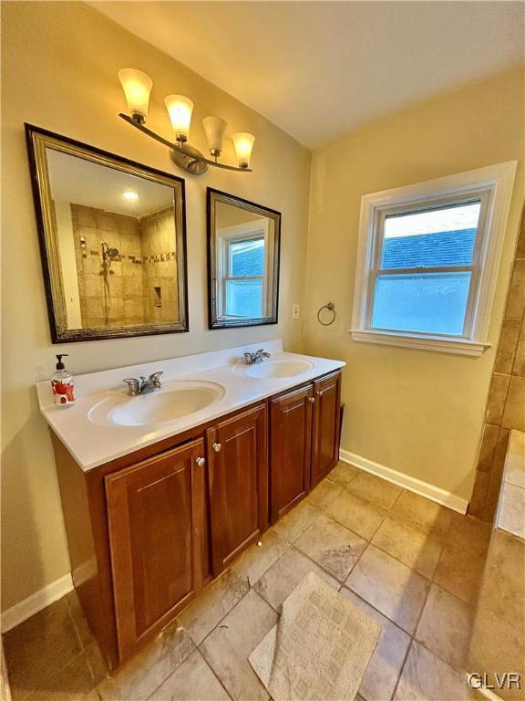 bathroom featuring double vanity, baseboards, and a sink