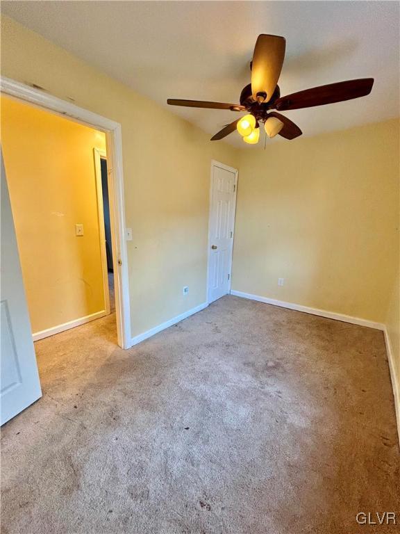 unfurnished bedroom featuring ceiling fan, baseboards, and carpet floors