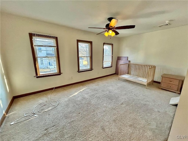 unfurnished bedroom featuring carpet flooring, visible vents, and baseboards