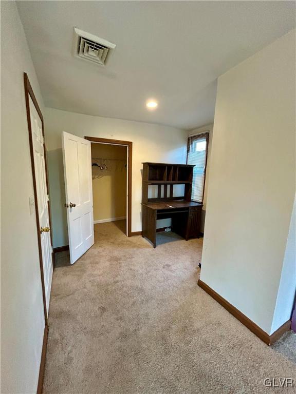 unfurnished bedroom with visible vents, light colored carpet, and baseboards