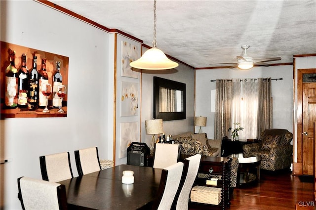 dining area with a textured ceiling, wood finished floors, a ceiling fan, and ornamental molding