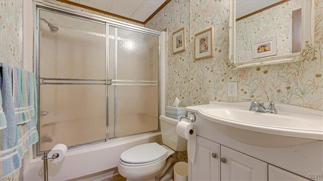 bathroom with wallpapered walls, toilet, vanity, and ornamental molding