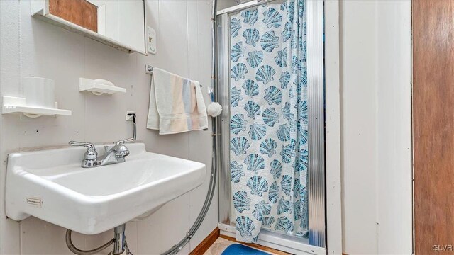 full bathroom featuring a shower stall and a sink