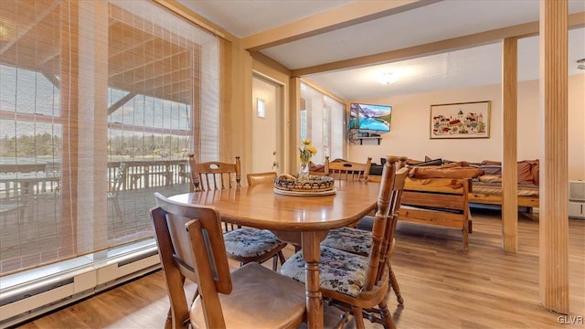 dining space featuring beam ceiling and light wood finished floors