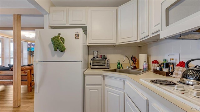 kitchen with white cabinetry, white appliances, light countertops, and a sink