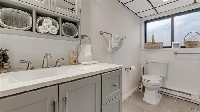 bathroom featuring vanity, toilet, baseboards, and baseboard heating