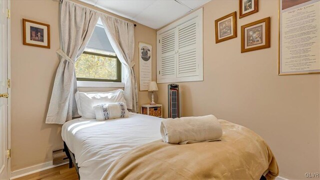 bedroom with baseboards and wood finished floors