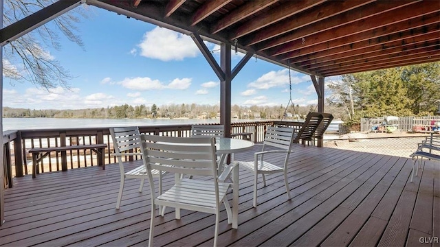 wooden deck with outdoor dining area and a water view