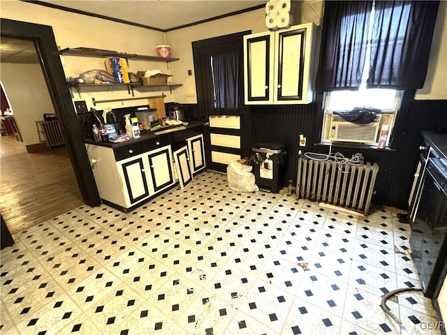 kitchen featuring radiator, light floors, and crown molding