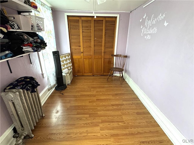 hall with baseboards and light wood finished floors