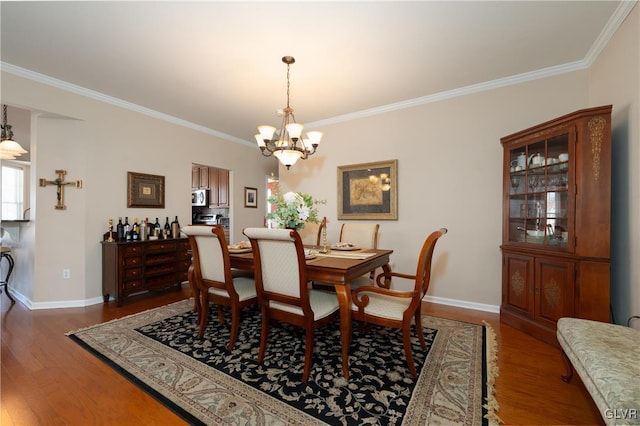 dining space featuring wood finished floors, crown molding, a notable chandelier, and baseboards