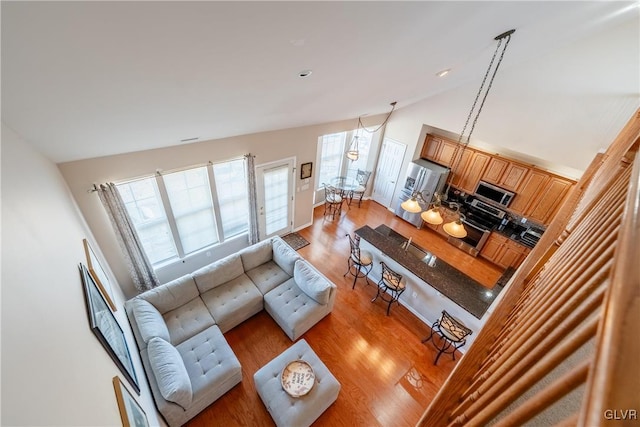 living room with light wood-style floors and high vaulted ceiling